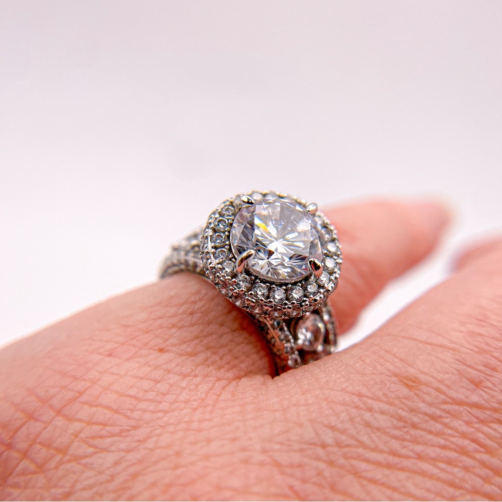 Round cut cubic zirconia silver toned ring with round accents. Size 5.